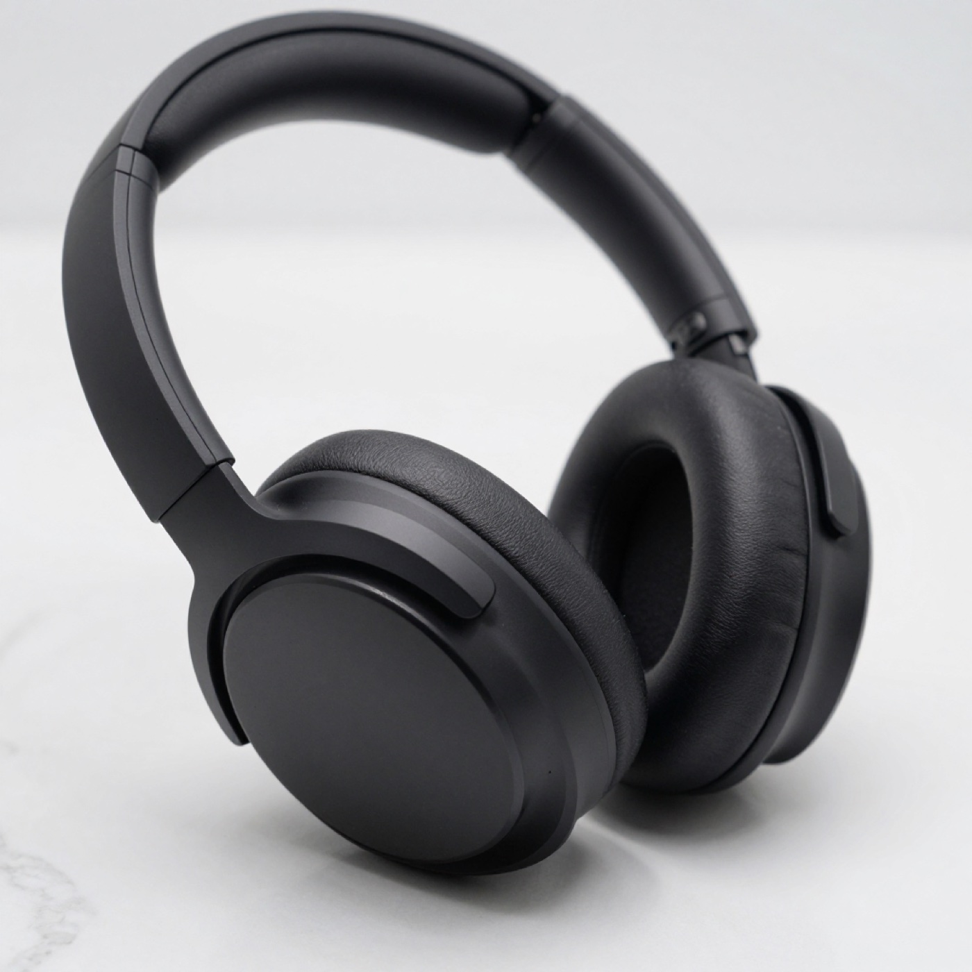Audífonos premium over-ear de cuero negro y aluminio en macro sobre mármol blanco, generada con Z-Image-Turbo